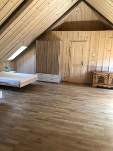 Cette chambre mansardée comprend un lit et un plafond en bois. dans l'établissement Chez Dodo 2534 Orvin Le Foncet, à Evilard