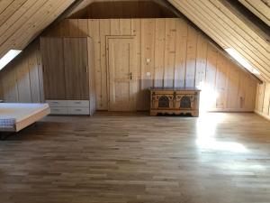 an attic room with a bed and a wooden floor at Chez Dodo 2534 Orvin Le Foncet in Evilard