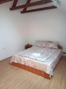 a bedroom with a bed with pink flowers on it at Pensiunea Valea Beiului in Socolari