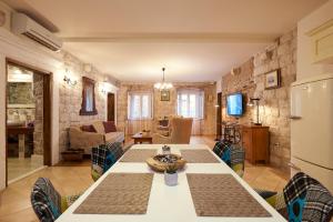una cucina e un soggiorno con tavolo e frigorifero di Apartment Capo Residence - Old Town - Parking a Trogir