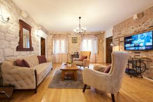 a living room with a couch and chairs and a tv at Apartment Capo Residence - Old Town - Parking in Trogir +84 photos