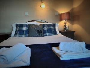 um quarto com uma cama com toalhas em The Imperial Hotel em Castle Douglas