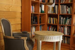 a table and a chair in front of a book shelf at Casa de l Bárrio in Picote