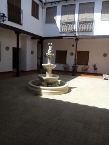 a large courtyard with a fountain in the middle of a building at Casa De Comedias in Almagro