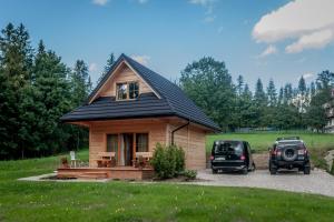 una pequeña casa con un coche aparcado delante de ella en Harny Domek, en Kościelisko