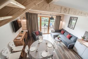 una sala de estar con una mesa y un sofá en Harny Domek, en Kościelisko
