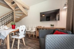 Una sala de estar con un sofá, una mesa y sillas. en Harny Domek, en Kościelisko
