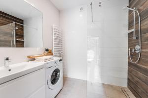 y baño blanco con lavadora y ducha. en Harny Domek, en Kościelisko 24 fotos más