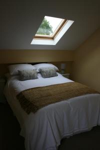 een slaapkamer met een groot bed en een dakraam bij Carrowbruagh in Limavady