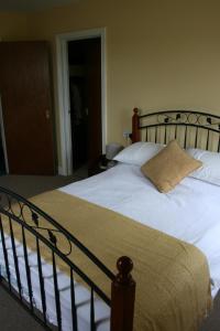 Una cama con sábanas blancas y una almohada. en Carrowbruagh en Limavady