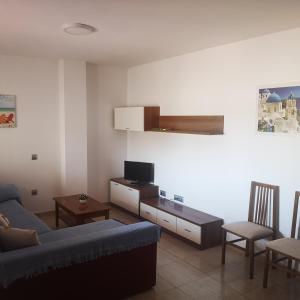 uma sala de estar com um sofá e uma televisão em CABO GATA SUNNY HOUSE em Retamar