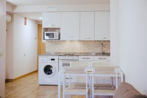 cocina con mesa y lavadora en Apartamentos Ducay, en Olite