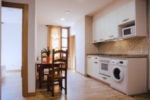 uma cozinha com uma mesa e uma máquina de lavar roupa em Apartamentos Ducay em Olite
