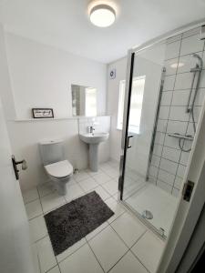 a bathroom with a shower and a toilet and a sink at Chelmsford Town Centre New Modern Apartments in Chelmsford