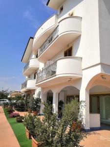 un edificio blanco con balcones y plantas en B&B Sperlonga, en Sperlonga