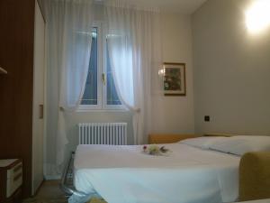 a bedroom with two beds and a window at Hotel Bruna in Lizzano in Belvedere