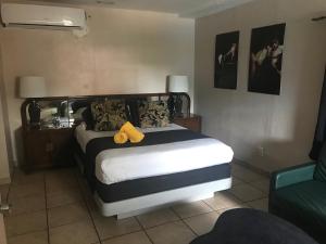 a hotel room with a bed, chair, and table at INN LEATHER GUEST HOUSE-GAY MALE ONLY in Fort Lauderdale