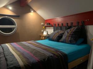 um quarto com uma cama com uma cabeceira vermelha em loft sur les montagnes em Saint-Michel-de-Chaillol