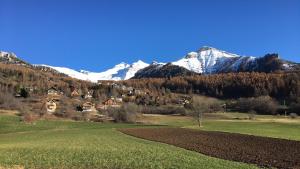 un champ avec des montagnes enneigées en arrière-plan dans l'établissement loft sur les montagnes, à Saint-Michel-de-Chaillol