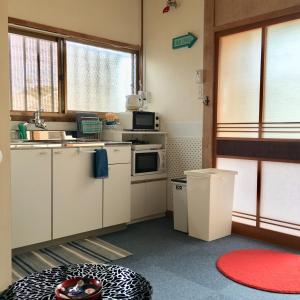 una pequeña cocina con electrodomésticos blancos y una ventana en One Rest Private House, en Naoshima