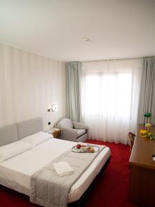 a hotel room with a bed with a tray of fruit on it at Hotel Tessarin in Taglio di Po