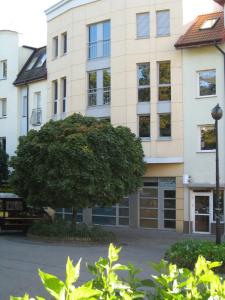 a large building with a tree in front of it at 5A Hotel Services in Koszalin