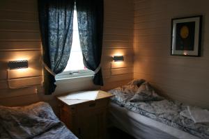 1 dormitorio con 2 camas individuales y ventana en Tinabua Rorbu Lofoten, en Stamsund