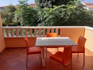 a table and chairs on a balcony with a table at Apartmani Ruža in Novalja
