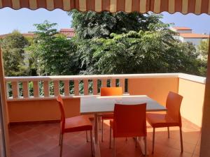 a table and chairs on a balcony with a view at Apartmani Ruža in Novalja