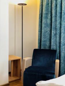 einem blauen Stuhl vor einem Vorhang in der Unterkunft Hotel zum Engel in Mespelbrunn