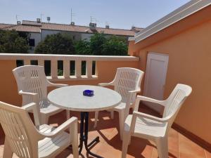 a patio with a table and chairs on a balcony at Apartmani Ruža in Novalja