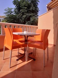 a patio table and chairs on a balcony at Apartmani Ruža in Novalja