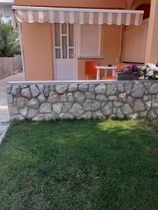a stone retaining wall in front of a house at Apartmani Ruža in Novalja