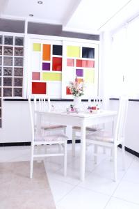 una sala da pranzo bianca con tavolo e sedie bianchi di Anchor and Rose a Salerno