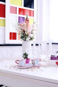 un tavolo con due tazze e un vaso con fiori di Anchor and Rose a Salerno