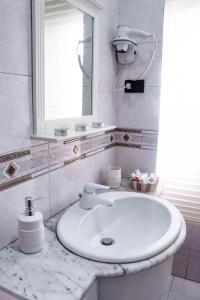 a white bathroom with a sink and a mirror at Anchor and Rose in Salerno
