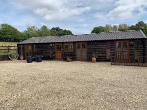 a cabin with wooden doors and a fence at Stable lodge 2 Bedrooms in Horspath