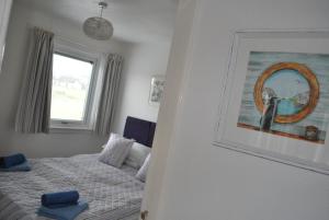 Isle of Whithornにある31 Laigh Isleのベッドルーム1室(ベッド1台付)が備わります。壁に絵が飾られています。