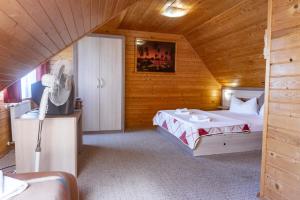 een slaapkamer met een bed in een houten hut bij Casa de vacanta ROUA DIMINETII in Beclean