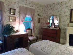 Barre的住宿－Couture Farm at Millstone Hill，一间卧室配有两张床、一个梳妆台和镜子