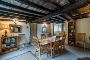 a dining room with a wooden table and chairs at Yew Tree Cottage in Moulsoe
