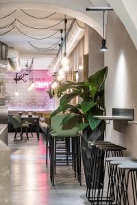 ein Restaurant mit Tischen und Stühlen und einer Pflanze in der Unterkunft Stay COOPER l Cooper apartments in Bozen