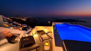 a pool on the side of a house at night at Antrum Cave Villa in Imerovigli