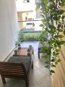 a room with a bench and a bunch of plants at Appartement Miramar in Mohammedia