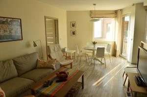 ein Wohnzimmer mit einem Sofa und einem Tisch in der Unterkunft Apartament Babitonga I in Puck