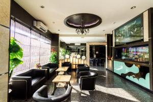 a bar with leather chairs and tables and a chandelier at Lovina Inn - Nagoya Batam in Nagoya