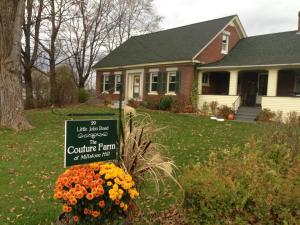 a house with a sign in front of a yard at Couture Farm at Millstone Hill in Barre