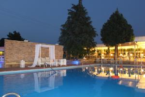 a swimming pool in front of a hotel at night at Chris & Eve Mansion in Komotini