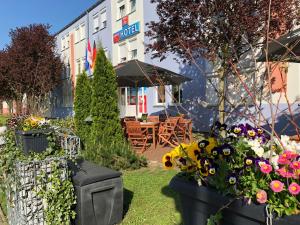 un jardín con flores frente a un hotel en centra Hotel en Schwedt