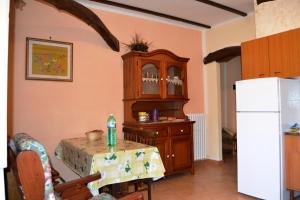 a kitchen with a table and a white refrigerator at Appartamento bello e comodo in Aritzo